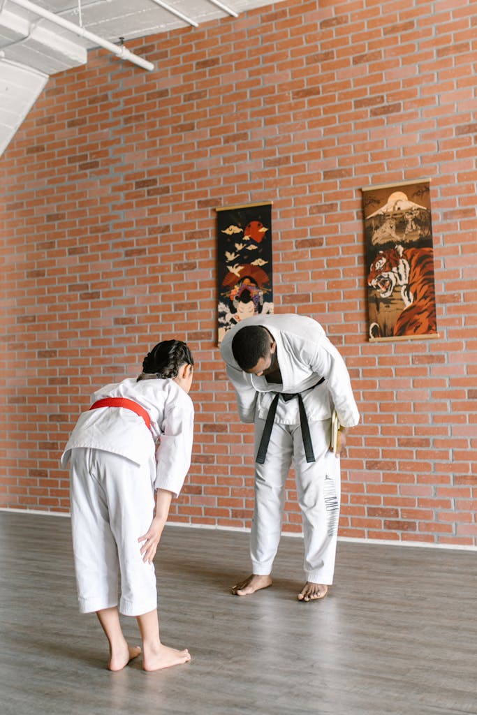 Man and Girl In Martial Arts Bowing Down