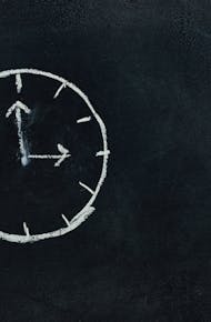 Chalk-drawn clock on a blackboard, symbolizing time and education concepts.